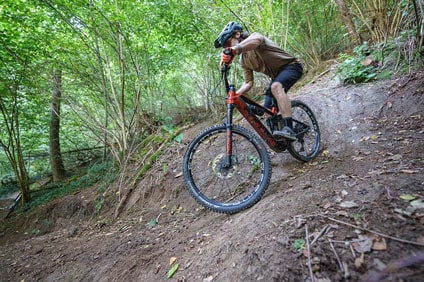 Mountainbiker op een steil bospad.