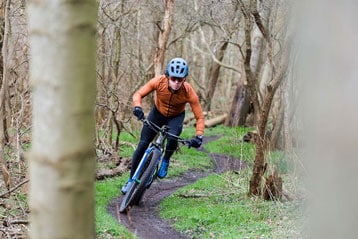 Fietser rijdt over een bospad.