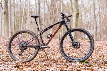 Mountainbike in een bos met gevallen bladeren.