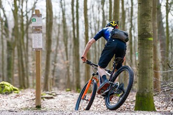 Fietser rijdt met een mountainbike door een bospad.