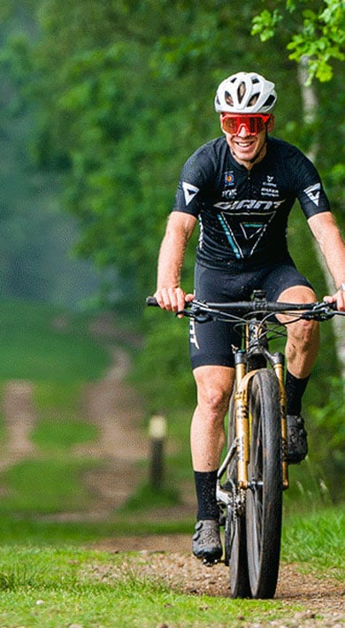 Twee fietsers rijden op een bospad.