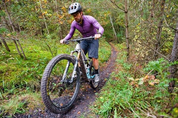 Mountainbiker op een bospad.