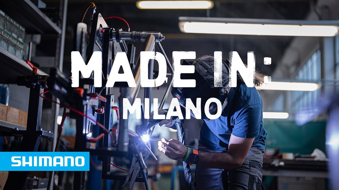 Shimano advertisement with text 'Made in: Milano' over a worker welding in a workshop