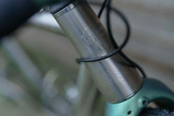 Close-up of a bicycle's front frame with raindrops