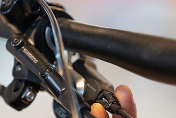 Nahaufnahme eines Fahrradlenkers mit Metallkomponenten, einschließlich eines Hebels.