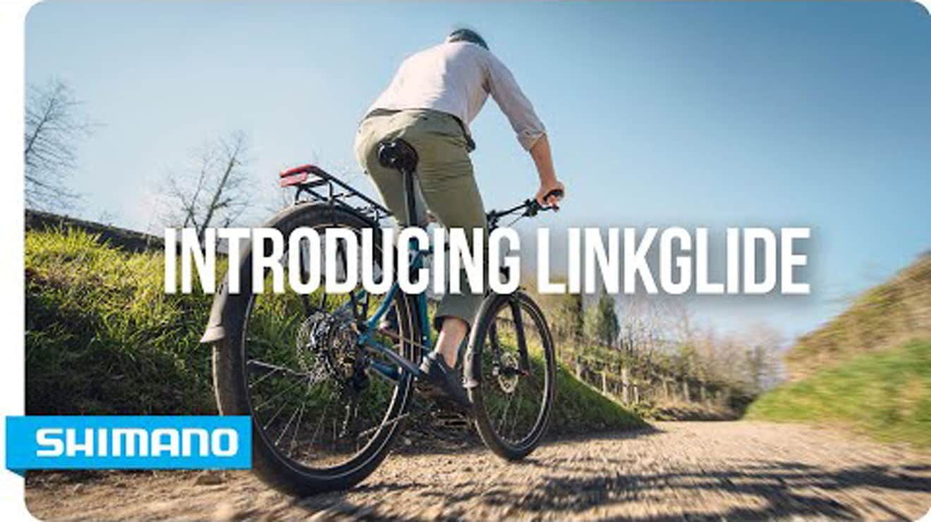 Cyclist riding on a dirt path with text 'Introducing Linkglide' and Shimano logo