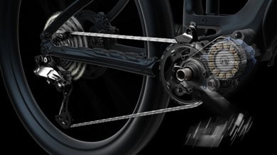 Close-up of a bike drivetrain and rear wheel in motion against a black background