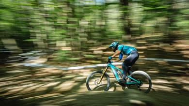 Cyclist riding a mountain bike through a forest with motion blur effect