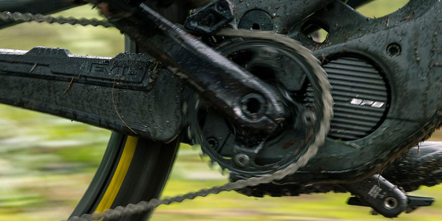 Close-up of a bicycle's drivetrain and chainring covered in mud and dirt.