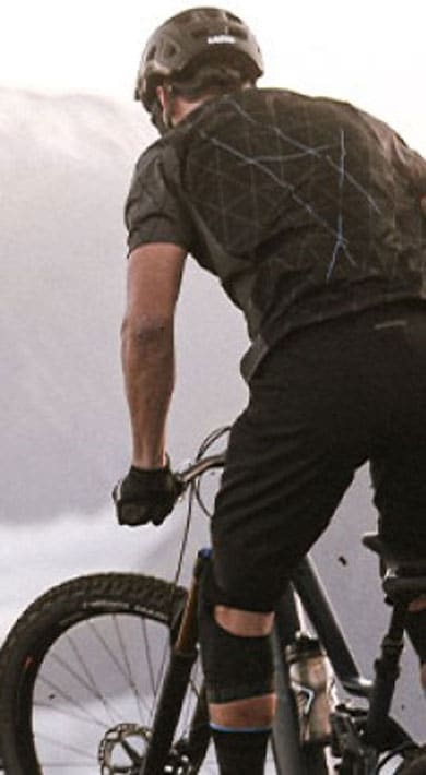 Mountain biker overlooking a foggy valley and distant snow-capped mountains