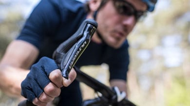 Cyclist in blue attire gripping Ultegra bike handlebar while riding