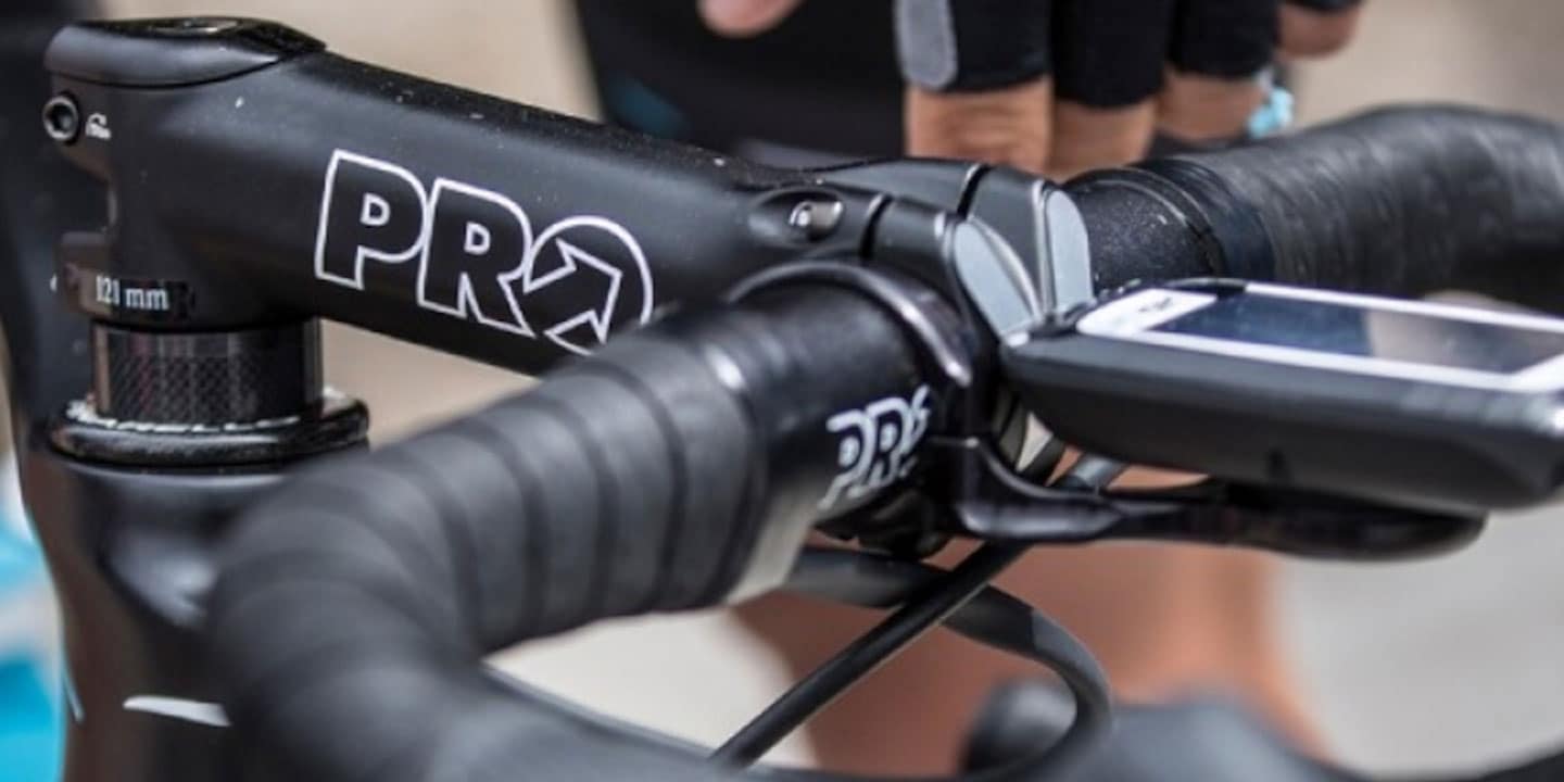 Close-up of a cyclist adjusting a bike handlebar with a mounted cycle computer