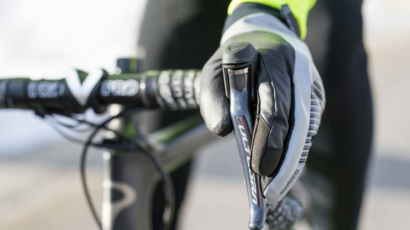 Cyclist wearing gloves gripping Shimano Ultegra brake lever on a road bike