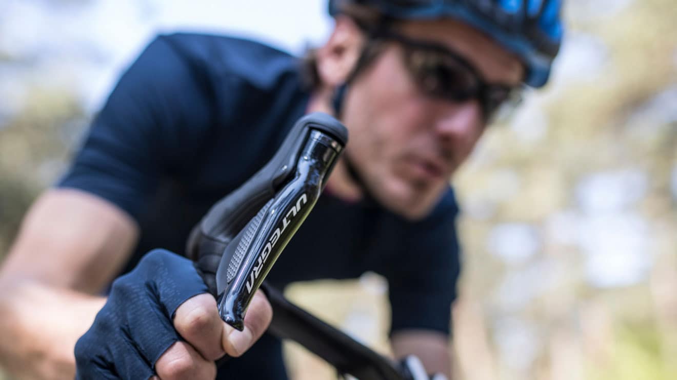 Cyclist gripping Ultegra bike handlebar, focus on the gear shifter