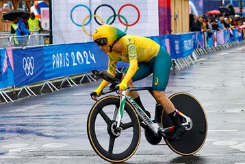 Ciclista com roupa amarela e verde durante uma corrida nas Olimpíadas de Paris de 2024