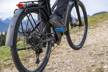 Person fährt mit einem Mountainbike auf einem Schotterweg.
