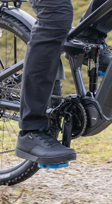 Person fährt mit einem Mountainbike auf einem Feldweg.