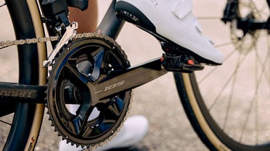 Close-up of cyclist pedaling a road bike with white shoes