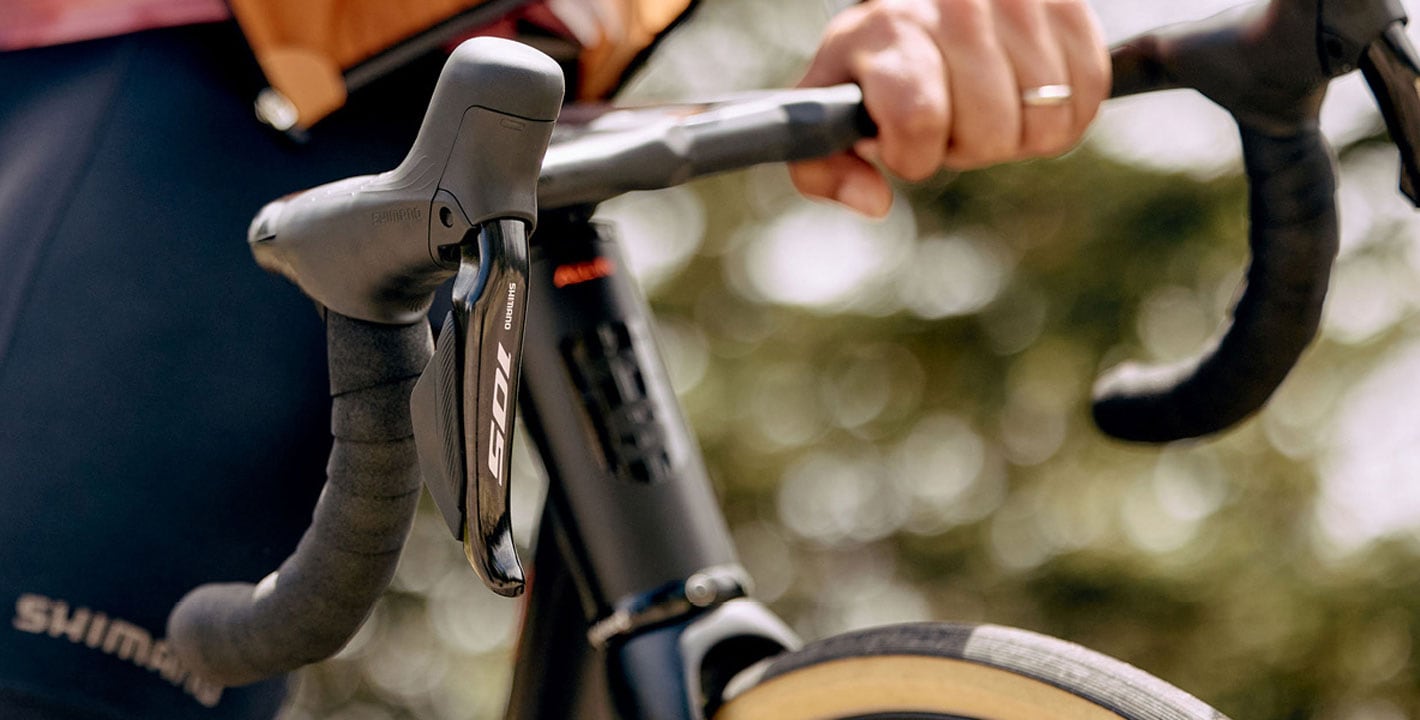 Close-up of cyclist's hands on handlebars with a smartwatch