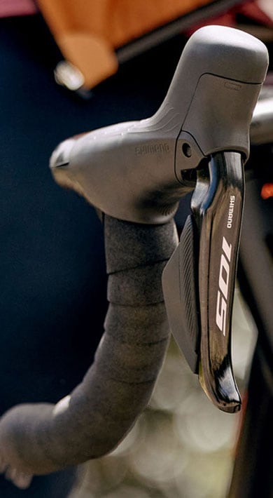 Close-up of cyclist's hands on handlebars with a smartwatch