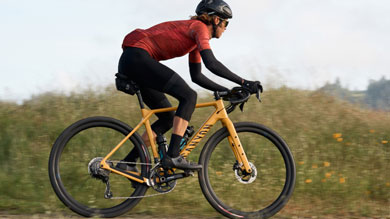 Cyclist riding a yellow Canyon bicycle on a grassy path