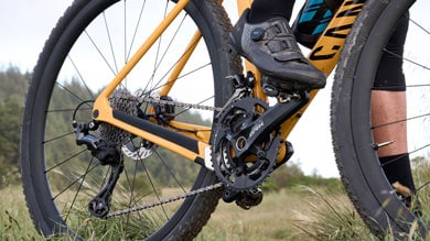 Cyclist pedaling a yellow bike on a grassy trail