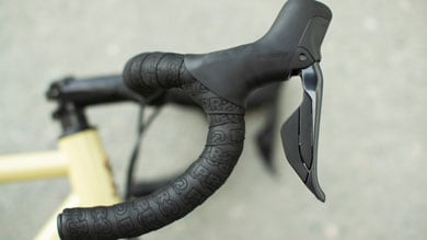 Close-up of a bicycle's handlebar with Shimano brake lever and black grip tape