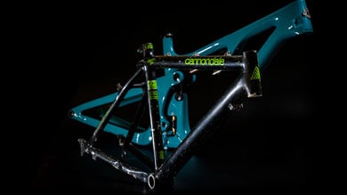 Cannondale bicycle frameset in black and teal on a dark background