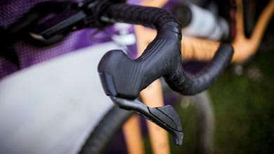 Close-up of a gloved hand gripping a bicycle handlebar