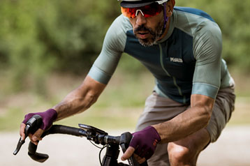 Cyclist in purple jersey riding a bike handlebar outdoors