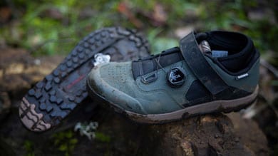 Pair of Shimano cycling shoes on a rock in an outdoor setting