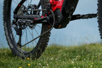 Close-up of a bicycle's rear wheel and pedal on grass