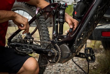 Person adjusting full-suspension mountain bike components