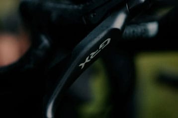 Close-up of GRX bicycle brake lever on a dark background