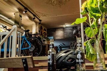 Fietswinkel met drankjes, helm en een vaas met zonnebloemen.