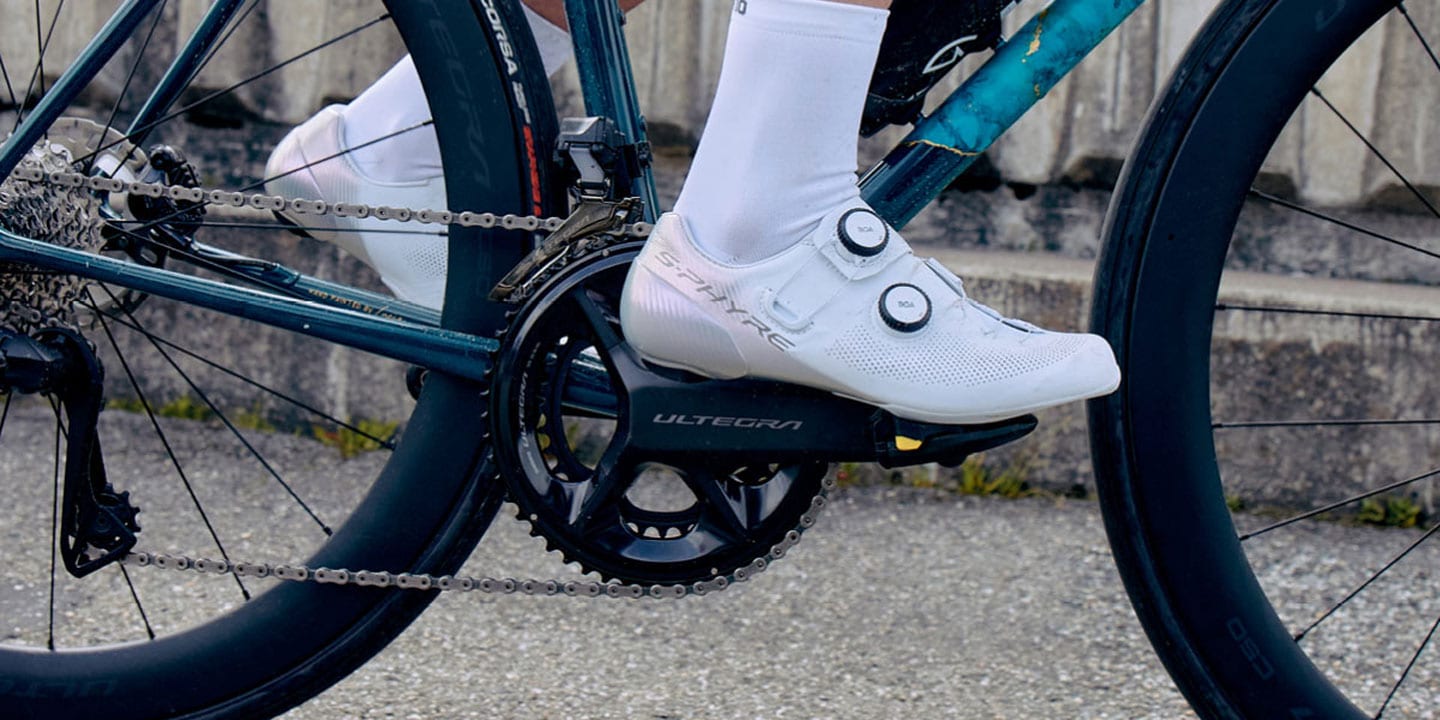 Cyclist wearing white shoes on a road bike with Shimano Ultegra components