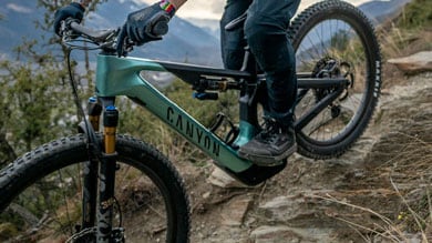 Person riding a Canyon mountain bike on a rocky trail.