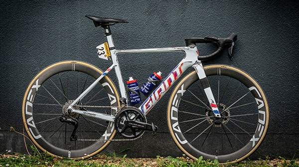 White racing bike with Cadex wheels and blue water bottles