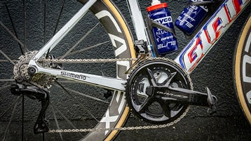 Close-up van een fietsaandrijflijn met Shimano componenten en twee bidons gemonteerd op het frame