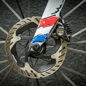 Close-up of a bicycle disc brake with colorful fork design