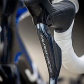 Close-up van een Dura-Ace fietsremgreep met wit stuurlint