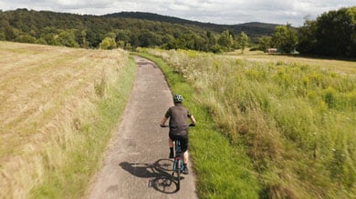 Radfahrer fährt auf einem Weg durch eine malerische Landschaft.