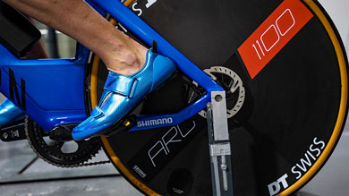 Nahaufnahme eines Fahrradreifens mit einer Person in blauen Schuhen, die aktiv während einer Testphase fährt.