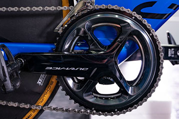 Nahaufnahme eines blauen Fahrrads mit Fokus auf die Kette und das Design des Fahrrads.