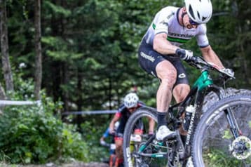 Cyclists racing on a muddy forest trail