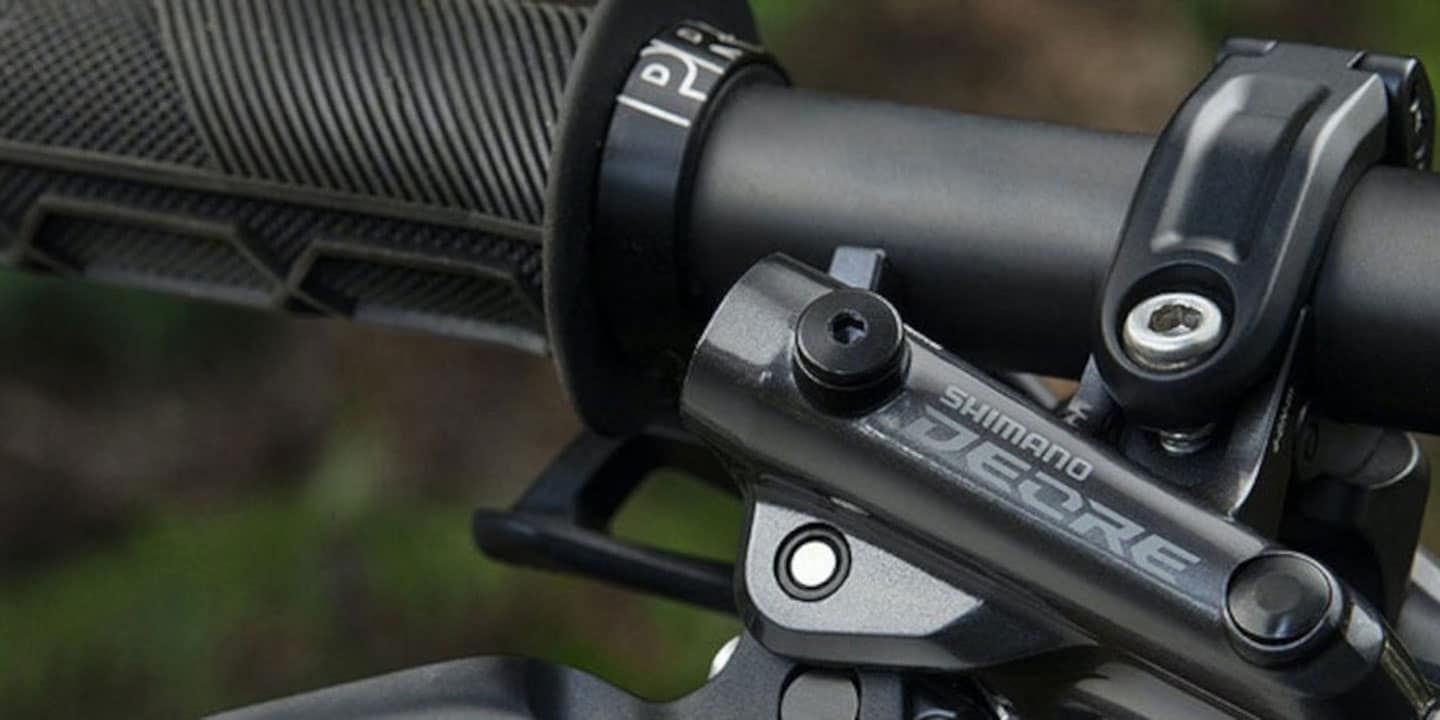 Close-up of a Shimano Deore mountain bike handlebar grip and brake lever assembly.