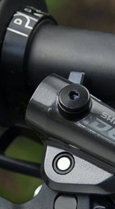 Close-up of a Shimano Deore mountain bike handlebar grip and brake lever assembly.