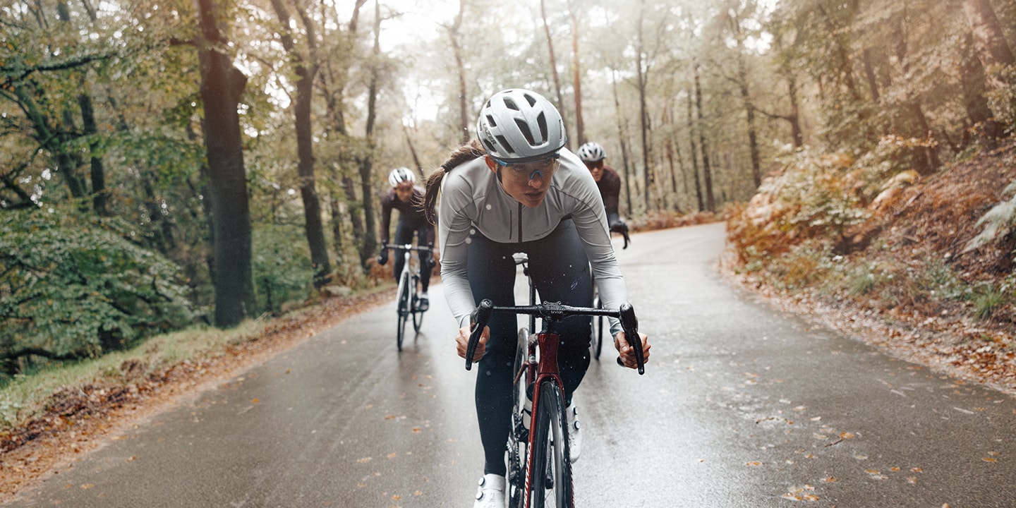 Women riding a road bike in winter while its raining 