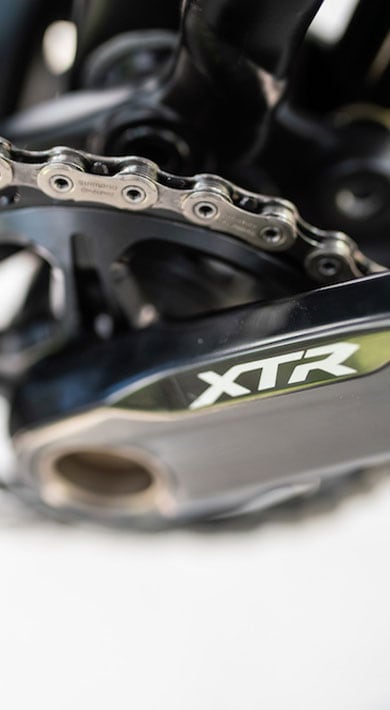 Primer plano del juego de bielas de bicicleta con cadena y logotipo XTR.