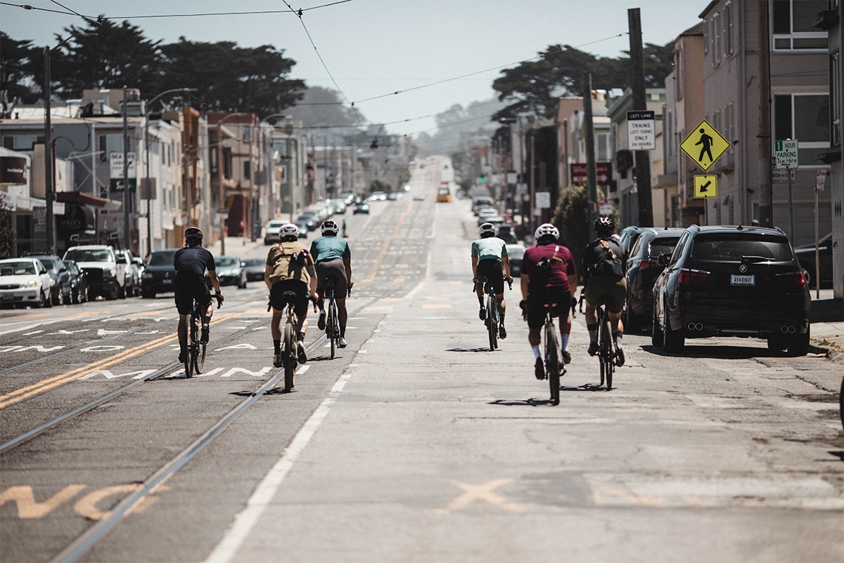 Group of cyclest riding bikes through parts of San Francisco on a sunny day
